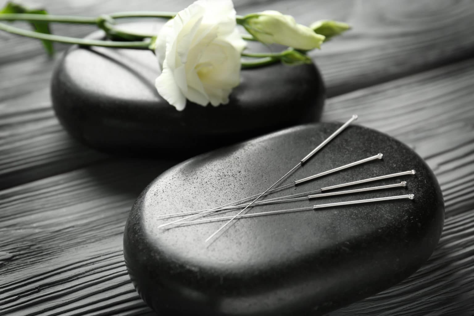 Aiguilles d'acupuncture posées sur un galet de soin
